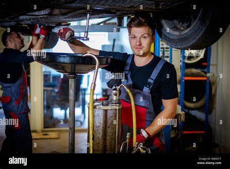 Car Mechanic Changes Oil In A Workshop Stock Photo Alamy