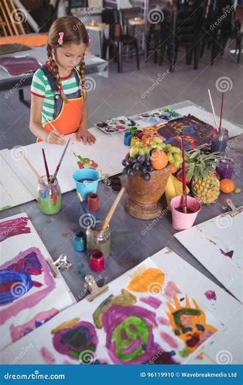 High Angle View Of Elementary Girl Painting On Paper Stock Photo