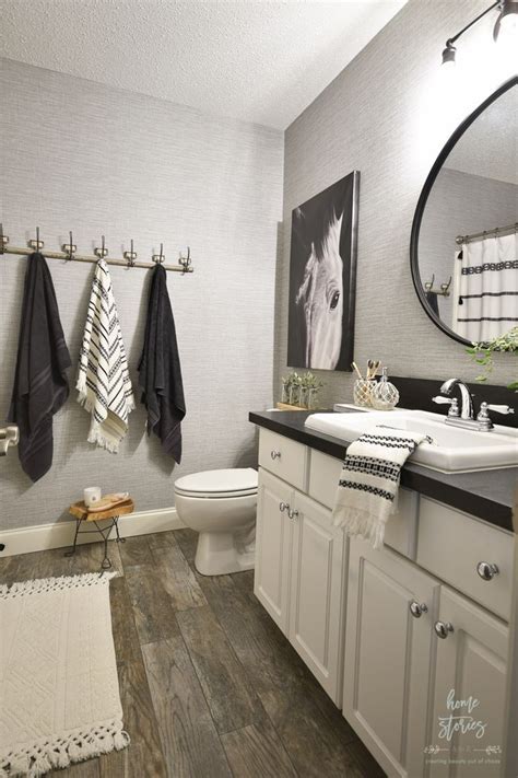 A Bathroom With White Cabinets And Black Counter Tops