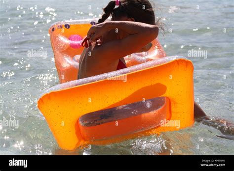 A Pretty Young Woman In Bikini Enjoying Sardinia Holiday In The Sea Water With A Lilo Raft