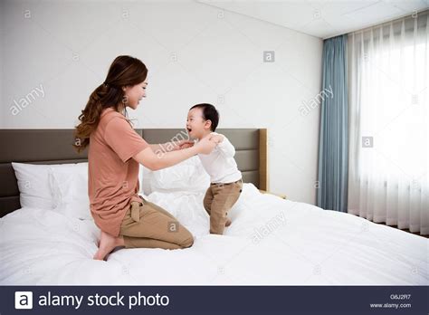 Asian Mother And Son Playing On The Bed At Home Stock Photo Alamy