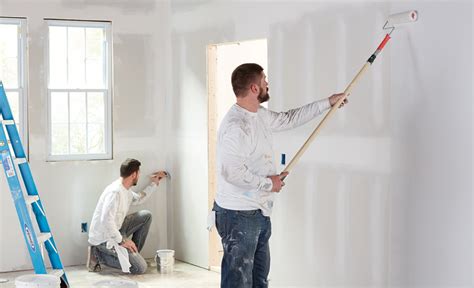 Two Men Painting A Wall In A Room Room Paint Painting Services