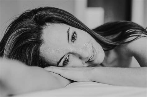 Young Beautiful Woman Sitting On Bed Resting And Smiling Lifestyle And Beauty Concept Stock