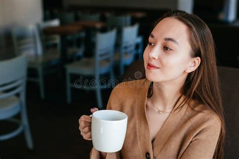 Close Portrait Of An Attractive Beautiful Girl Holding And Drinking A
