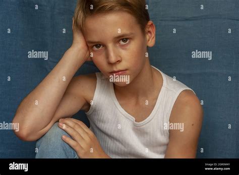 Portrait Of Teenage Boy Sitting Against Wall Stock Photo Alamy