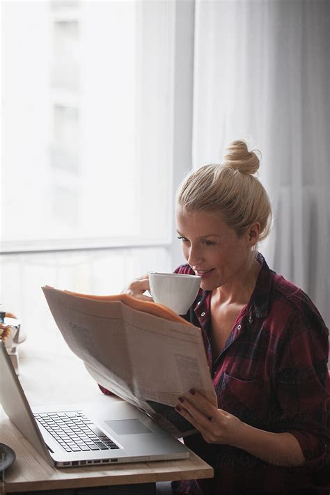 Happy Woman Reading The Newspaper And Drinking Coffee Del Colaborador De Stocksy Lumina