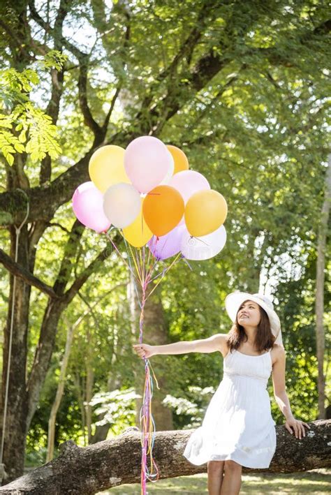 Cheerful Beauty Woman Holding Balloons Relax Sitting Under Big Tree In