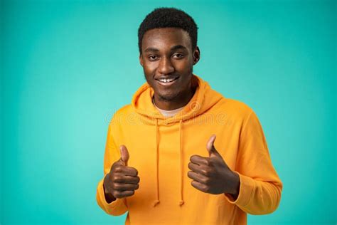 Smiling African American Man Showing Thumb Up At Camera In Studio Stock