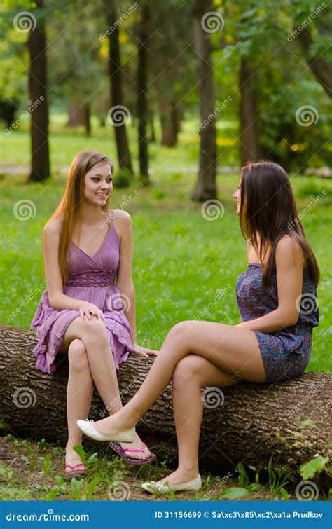 Two Girls Talking While Sitting In The Forest Stock Image Image Of