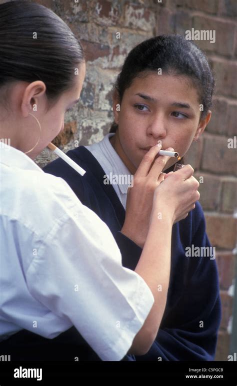 Two Secondary Schoolgirls Smoking Behind Wall Stock Photo Alamy
