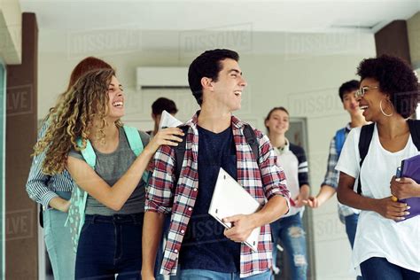 Students Laughing As They Walk Together On Campus Stock Photo Dissolve
