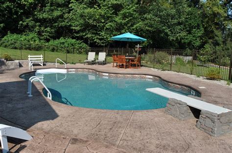 In Ground Pool Featuring A Vinyl Liner And Hardscape Diving Board Base