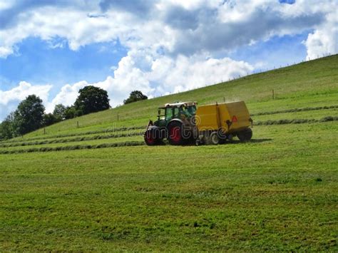 Tractor Mowing Grass On A Sloping Meadow In Midsummer Stock Image
