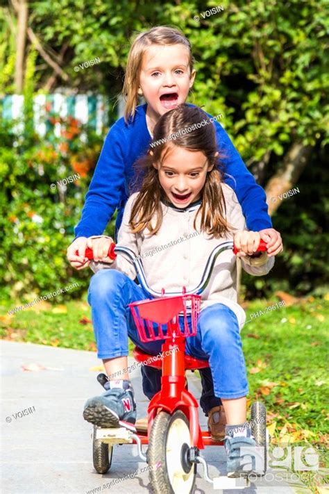 5 And 7 Years Old Girls Riding A Bicycle Stock Photo Picture And