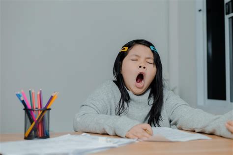 Premium Photo Asian Girl Yawning While Working On A Desk