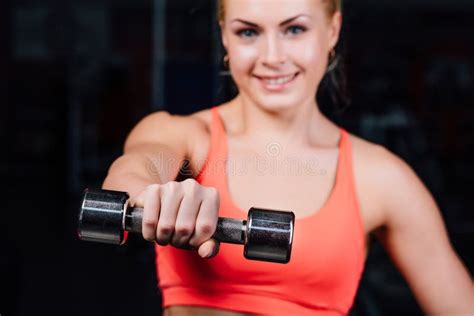 Сексуальная девушка делая тренировки в ее pectoral мышце фитнес с гантелями в спортзале славная