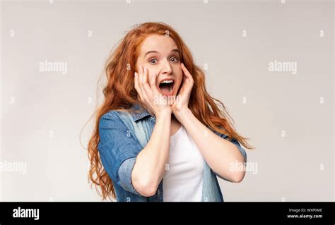 Millennial Redhead Girl Clutched Her Face In Shock And Surprise Stock