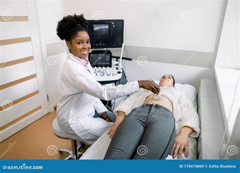 Young Black Woman Doctor Sonographer Using Ultrasound Machine At Work