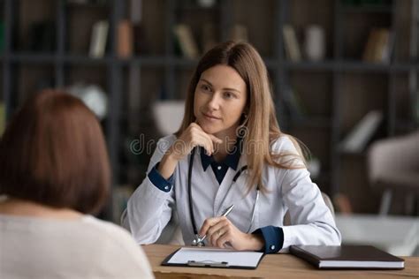 Caucasian Female Doctor Consult Mature Patient In Clinic Stock Image