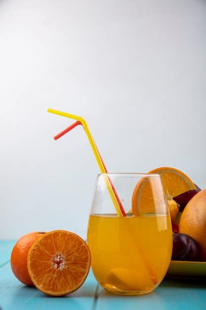 Free Photo Front View Orange Juice In A Glass With Straws And Oranges