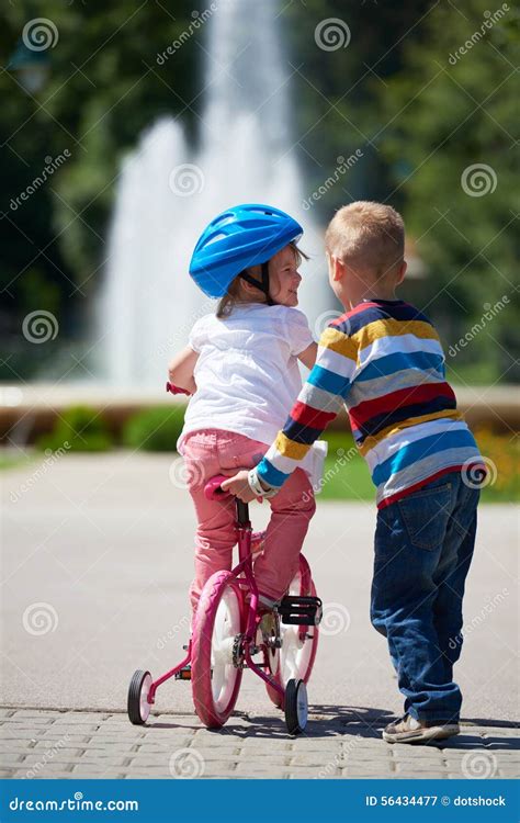 ragazzo e ragazza in parco che imparano guidare una bici immagine stock immagine di impari