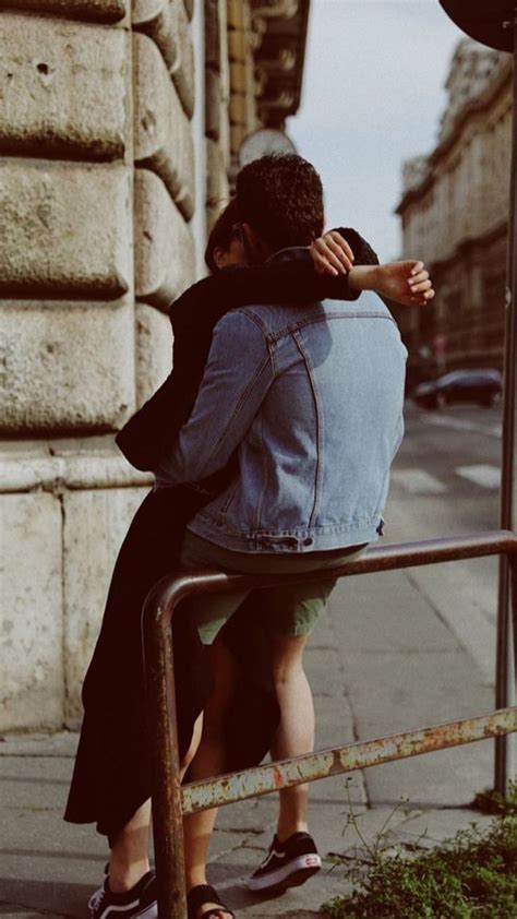 Two People Sitting On A Bench With Their Backs To Each Other One Holding The Back Of Another