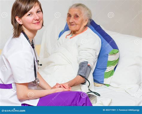 Young Nurse Caregiving An Old Lady Lying In Bed Stock Image Image Of