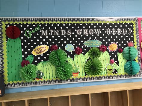 A Bulletin Board Decorated With Paper Flowers And Cactus