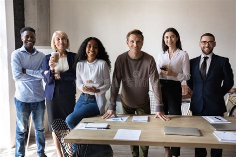 Portrait Of Smiling Diverse Employees Posing Together In Office Stock