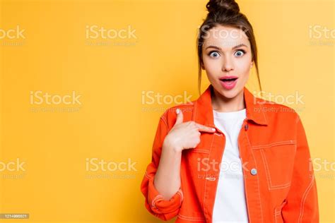 Shocked Girl Pointing With Finger At Herself While Looking At Camera On