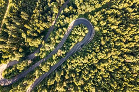 Aerial View Of Winding Road In High Mountain Pass Trough Dense Green