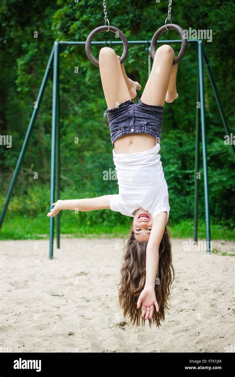 Girl Hanging Upside Down In A Playground Stock Photo Alamy