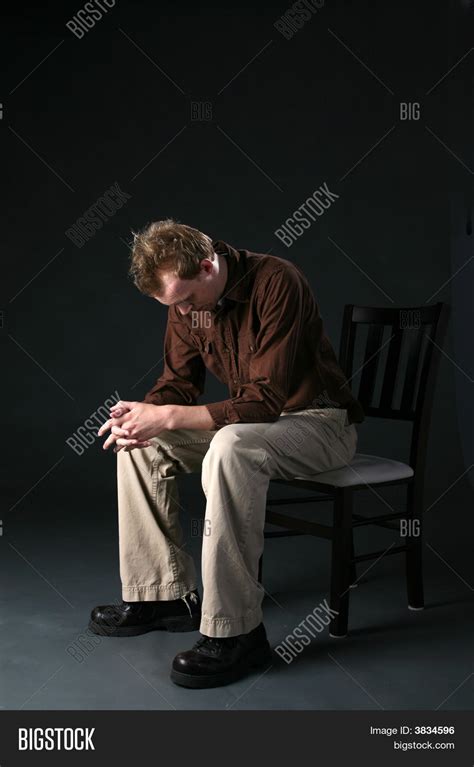 Man Sitting In Chair With Head Down Looking Sad Stock Photo And Stock