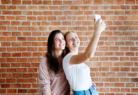 Premium Photo Smiling Female Friends Taking A Selfie