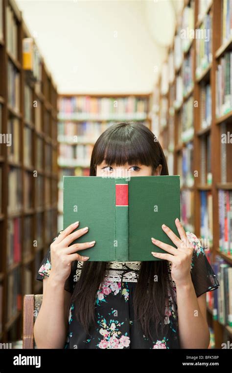Asian Woman Reading Book In Library Stock Photo Alamy