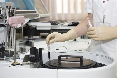 Person Wearing White Blouse Holding Clear Glass Test Tube And Placing