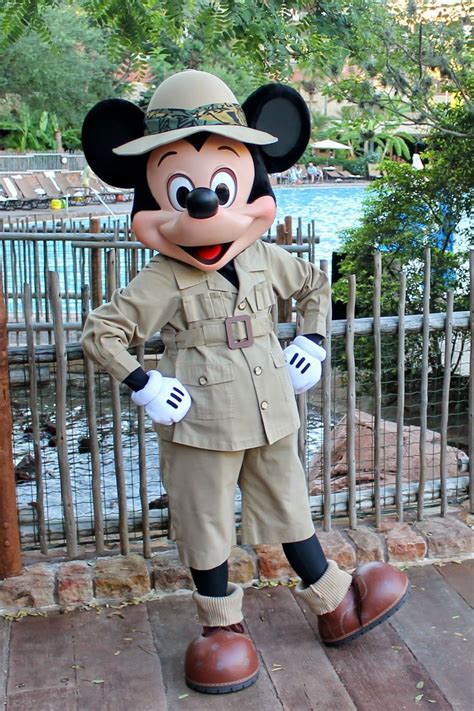 A Mickey Mouse Dressed In An Army Uniform Standing Next To A Fence And