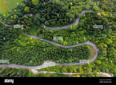 Aerial View Of A Winding Countryside Road Passing Through The Green