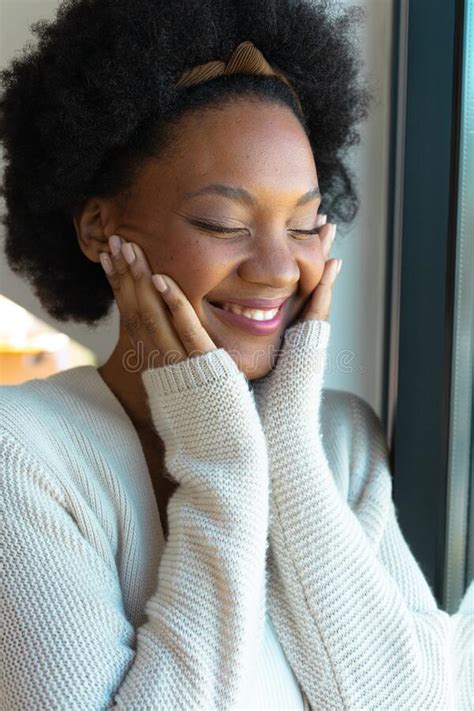 Close Up Of Smiling African American Young Afro Woman With Eyes Closed Touching Her Cheeks At