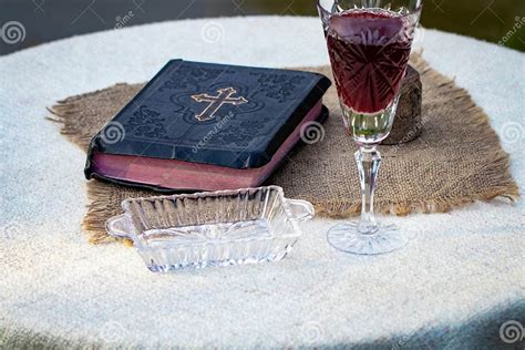 Taking Communion Cup Of Glass With Red Wine Bread And Holy Bib Stock