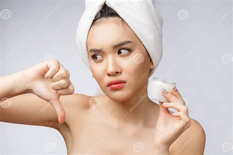 Beauty Portrait Of Half Naked Asian Woman Looking On Camera And Holding Face Cream On Her Palm
