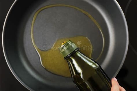 Woman Pouring Olive Oil Onto Frying Pan On Stove Stock Photo Image Of