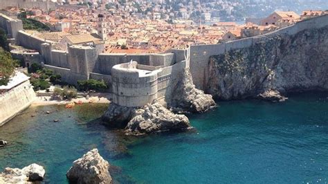 An Aerial View Of The Ocean And City From Above With Rocks In The