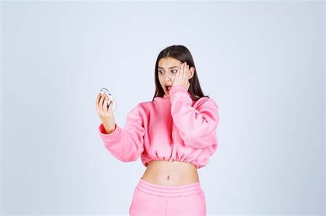 Free Photo Girl In Pink Pajamas Holding An Alarm Clock And Realizing