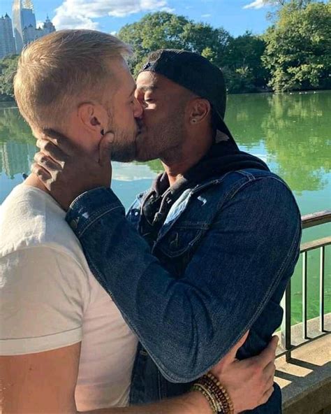 Interracial Gay Couple Embracing Love By The Lake