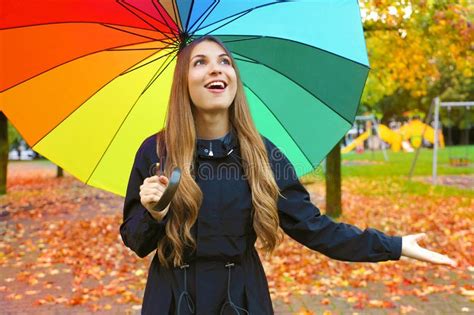 woman happy with umbrella under the rain during autumn forest walk girl enjoying rainy fall day