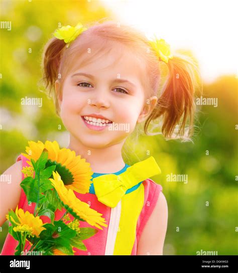 Closeup Portrait Of Cute Little Girl Holding Bouquet Of Fresh Yellow