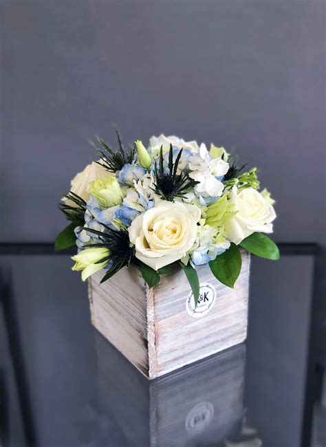 Maybe you would like to learn more about one of these? Small wood box with white roses and eustomas and blue ...
