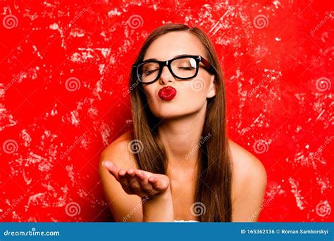 Pretty Girl With Glasses Sending A Kiss Against The Red Background 库存照片