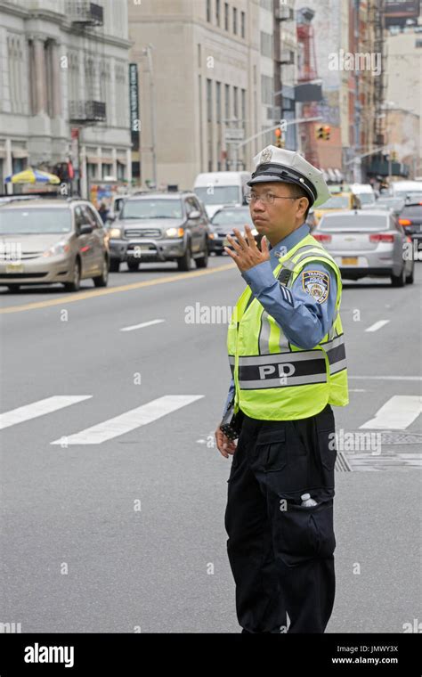 An Asian Male Traffic Cop Directing Traffic On Cana Street In Chinatown